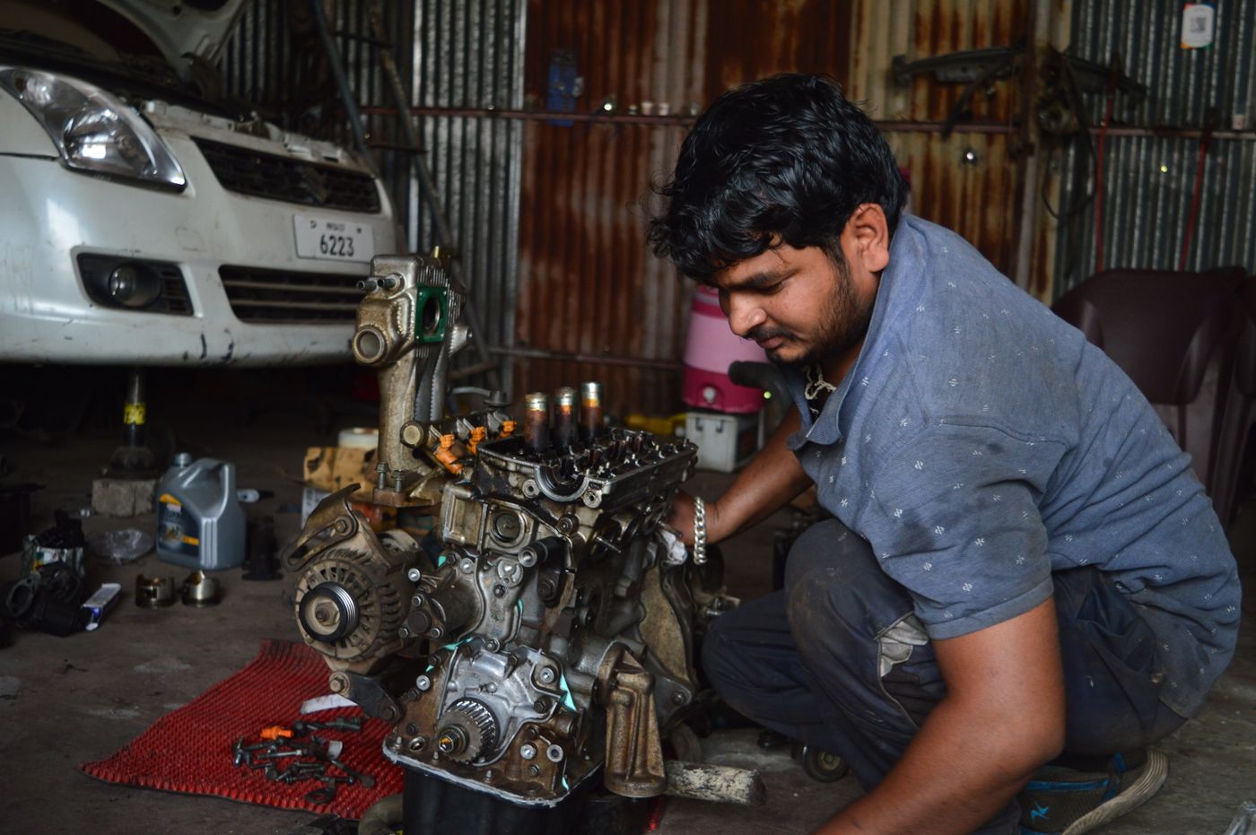 Indian mechanic repairing an engine in a local workshop