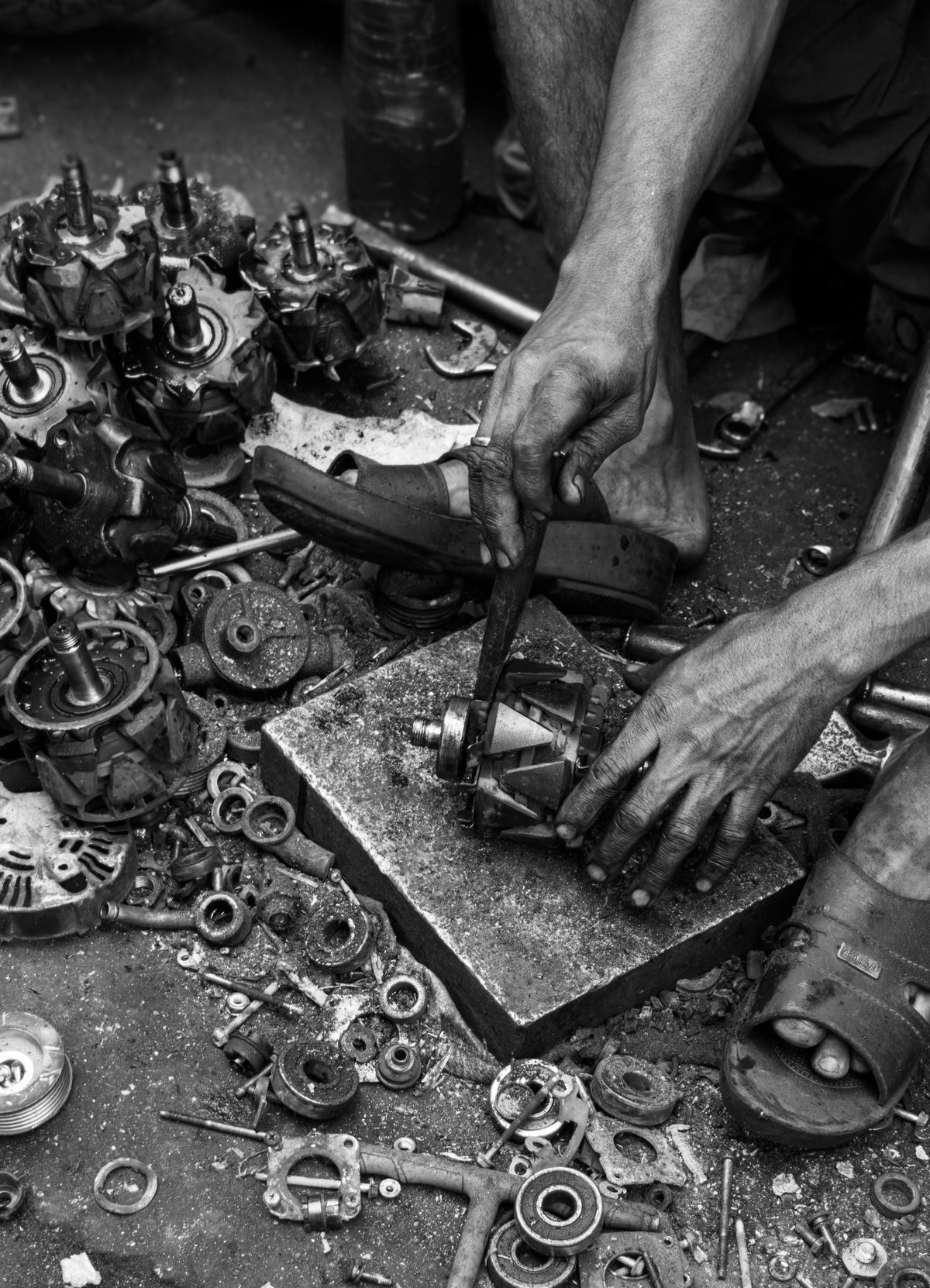 Indian mechanic working with components in a Mumbai workshop